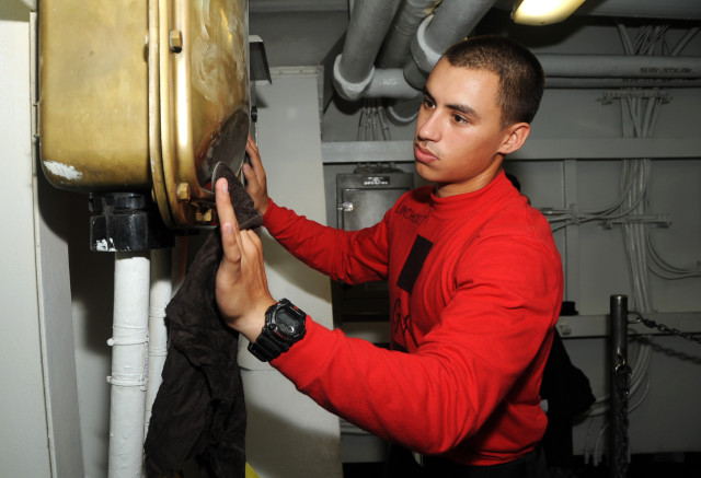 140721-N-MU440-025 ARABIAN GULF (July 21, 2014) Aviation Ordnanceman Airman Joseph Lindhout, from Mansfield, Ohio, polishes brass aboard the aircraft carrier USS George H.W. Bush (CVN 77). George H.W. Bush is supporting maritime security operations and theater security cooperation efforts in the U.S. 5th Fleet area of responsibility. (U.S. Navy photo by Mass Communication Specialist 3rd Class Lorelei Vander Griend/Released)